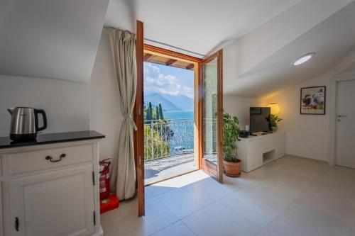 a kitchen with a large glass door leading to a balcony at Marble House Varenna Lake Como in Varenna