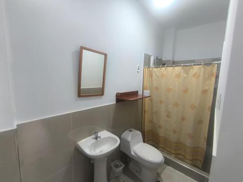 a bathroom with a sink and a toilet and a mirror at JJ Guest House Kuelap in Nuevo Tingo