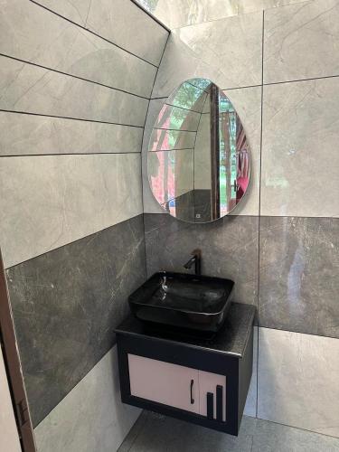 a bathroom with a black sink and a mirror at Riva farmstay in Mayyanād