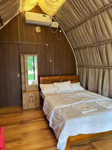 a bedroom with a bed in a tent at Riva farmstay in Mayyanād