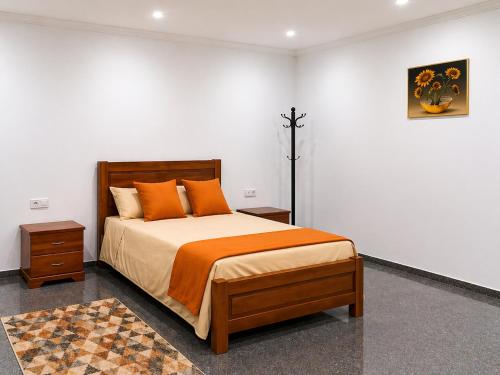 a bedroom with a large bed with orange pillows at Praia City Apartments in Praia