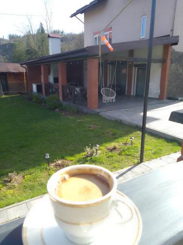 a cup of coffee on a table in front of a house at Riverside in Slavske