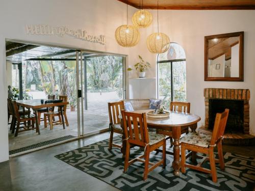 a dining room with a table and chairs and a fireplace at Malandela's Guest House in Malkerns