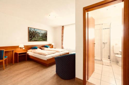 a hotel room with a bed and a bathroom at Diekstuv Hotel in Jork