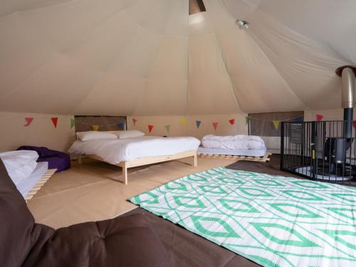 a room with two beds and a rug in a tent at YHA Conwy in Conwy