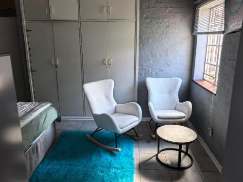 two chairs and a table in a room at Calming Waters Guesthouse in Grahamstown