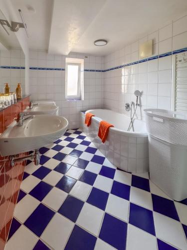 a blue and white bathroom with two sinks and a tub at Ferienhaus Pippan in Velden am Wörthersee