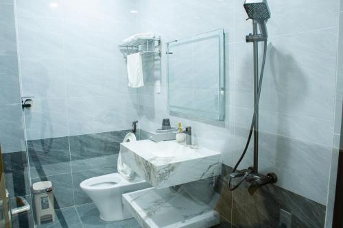 a bathroom with a toilet and a sink and a mirror at Sunflower Hotel in Nhơn Trạch