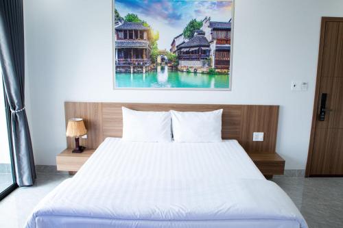 a bedroom with a bed and a painting on the wall at Sunflower Hotel in Nhơn Trạch