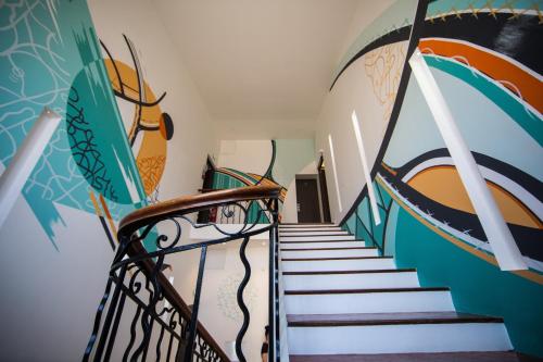 a staircase with a painting on the wall and a stair case at Negrecoste Hôtel & Spa in Aix-en-Provence