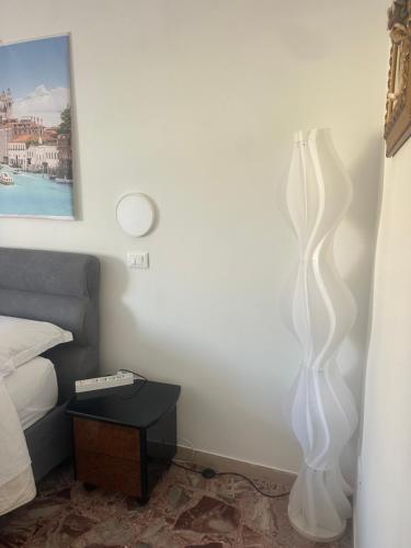 a bedroom with a white floor lamp next to a bed at stazione Lina house in Mestre