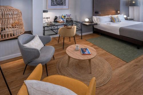 a hotel room with a bed and a table and chairs at Hotel SERHS Rivoli Rambla in Barcelona