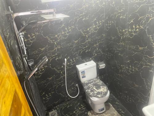 a bathroom with a toilet and a black wall at D & D Beach Resort in Trincomalee