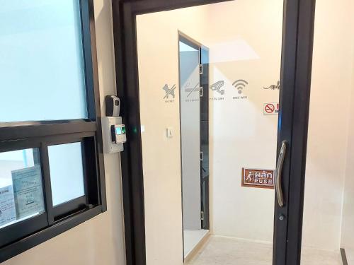 a door with a mirror in a room at Lynn Living (ลินน์ ลิฟวิ่ง) in Ban Non Muang