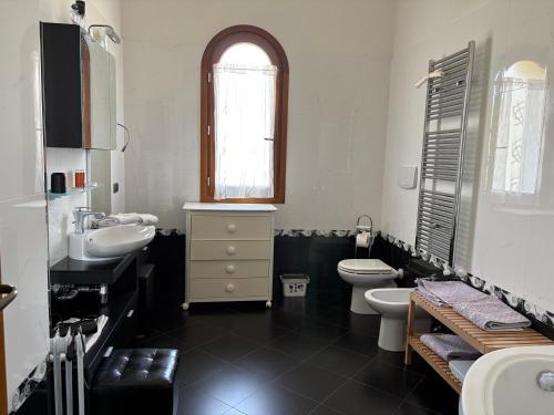 a bathroom with a sink and a toilet and a window at Les Lauriers, chambre d'hôtes in Siamanna