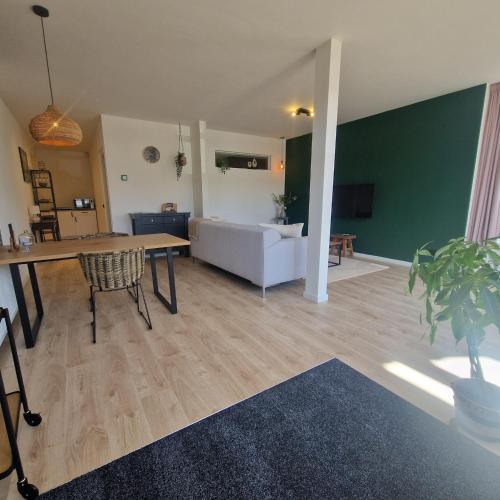a living room with a couch and a table at 't Westeind, Modern en sfeervol appartement in Norg in Norg