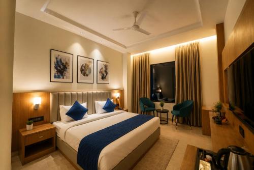 a hotel room with a large bed and a desk at Hotel Rs Vista - Agra in Agra