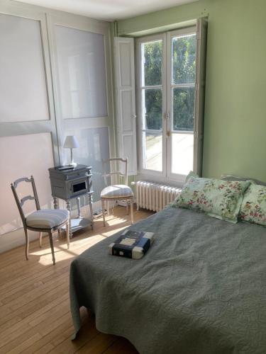 a bedroom with a bed and a table and chairs at Superbe maison calme au centre ville in Blois