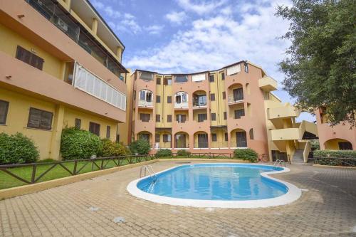 a building with a swimming pool in front of a building at Tilly by DomusAway in Olbia