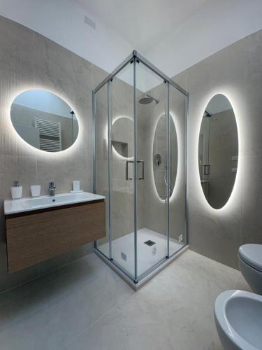 a bathroom with a shower and a sink and two mirrors at Casa Acqua e Sale - 50 mt dal mare in Fano