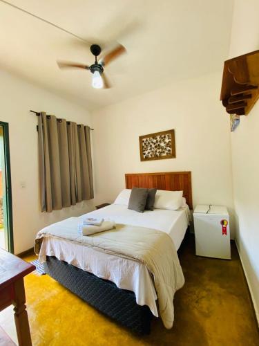 a bedroom with a bed and a ceiling fan at Hospedaria Estrada Real in Tiradentes