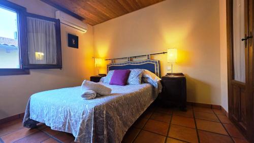 a bedroom with a bed and two lamps and a window at Casa Rural TioMoreno by Naturadrada in La Adrada