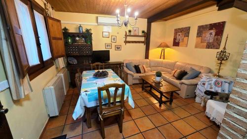 a living room with a table and a couch at Casa Rural TioMoreno by Naturadrada in La Adrada