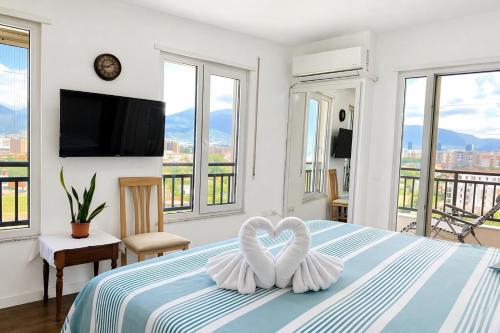 a bedroom with a bed with two towels in the shape of a heart at Romantic Penthouse with Mountains View in Kashari
