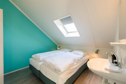 a small bedroom with a bed and a sink at Repos (6p) in Nes
