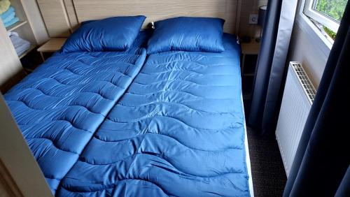 a blue bed in a van with blue pillows at Beach Resort Kamperland - 765 in Kamperland