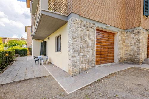 a house with a wooden garage door and a table at Tuscan Sunrise Home in Monteriggioni