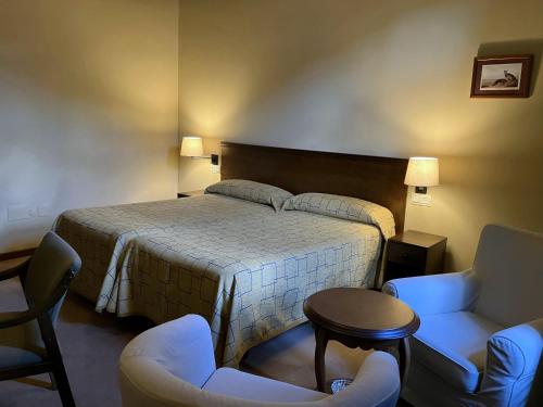 a hotel room with a bed and two chairs at Hotel Finca Los Venancios in Bones