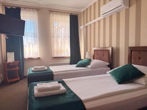a hotel room with two beds with towels on them at Noclegi-Restauracja Boss in Mogilno