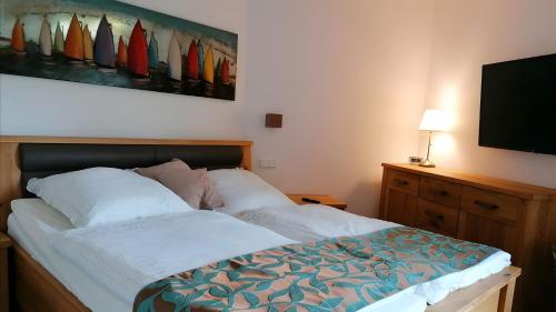a bedroom with a bed and a flat screen tv at Ferienwohnung Boddenblick-Vilm in Putbus