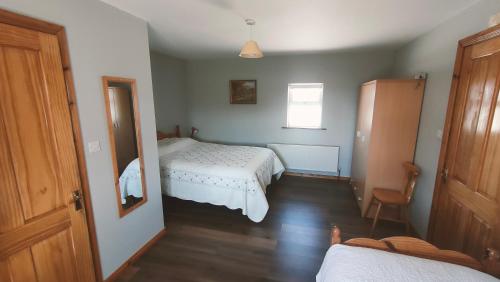 a small bedroom with two beds and a window at Danubio Guest Accommodation in Doonbeg