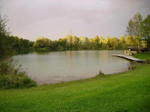 a lake with two picnic tables on a dock at Wiflinger Graben Einfamilienhaus in Wörth