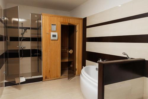 a bathroom with a tub and a glass shower at Hotel 4x4 in Rivne