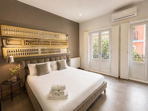a bedroom with a large white bed in a room at Abalú Collection Suites Gran Via in Madrid
