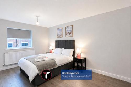 a bedroom with a bed and two lamps and a window at Spacious 4 Bedroom By Tara Stays Short Lets & Serviced Accommodation Aldershot With Free WiFi & Garden in Aldershot