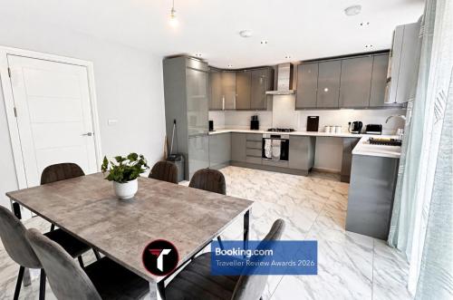 a kitchen and dining room with a table and chairs at Spacious 4 Bedroom By Tara Stays Short Lets & Serviced Accommodation Aldershot With Free WiFi & Garden in Aldershot