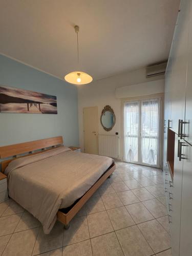 a bedroom with a bed and a large window at Mare & Pineta in Punta Marina