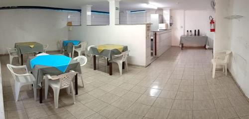 a room with tables and chairs and a kitchen at Hotel Kairós in Campinas