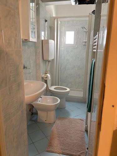 a bathroom with a sink and a toilet and a shower at Mare & Pineta in Punta Marina