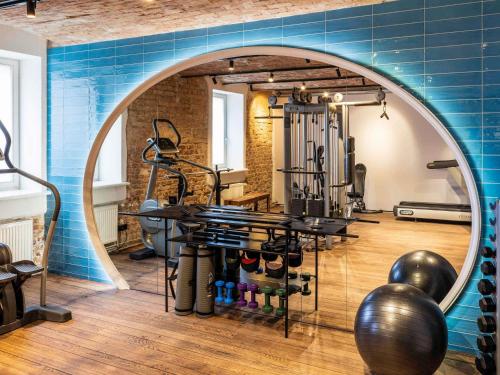 a gym with a blue wall and exercise equipment at TRIBE Riga City Centre - Renovated 2026 in Riga