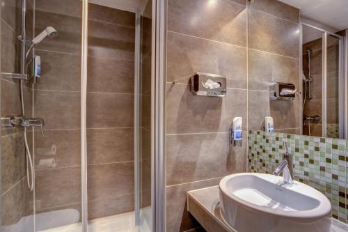 a bathroom with a sink and a shower at MEININGER Hotel Berlin Mitte in Berlin