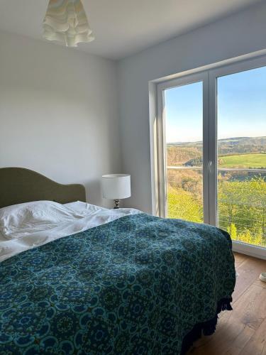 a white bedroom with a bed and a large window at HeartArt 2 in Bad Münstereifel