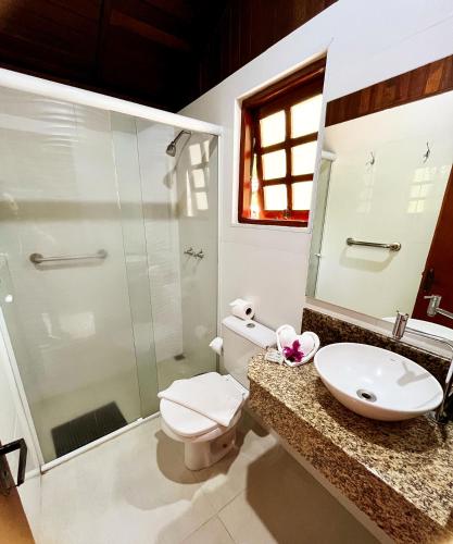 a bathroom with a toilet and a sink and a shower at Pousada da Cachoeira in Monte Alegre do Sul