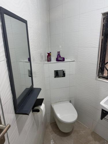 a white bathroom with a toilet and a mirror at Hilltop Villa Sengabay in Salima