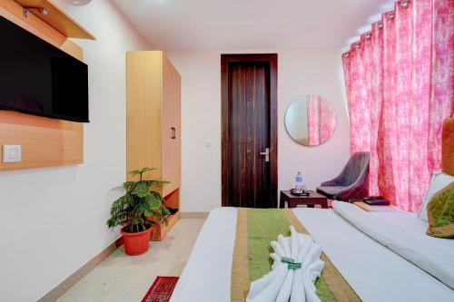 a hotel room with a bed and a tv at Roomquet comfort in Prayagraj