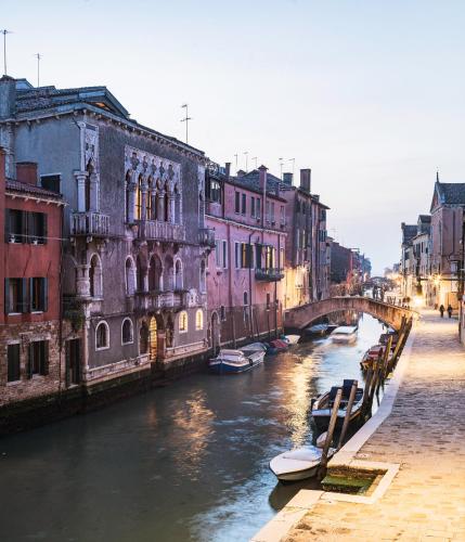 a view of a canal with buildings and a bridge at Hotel Heureka in Venice